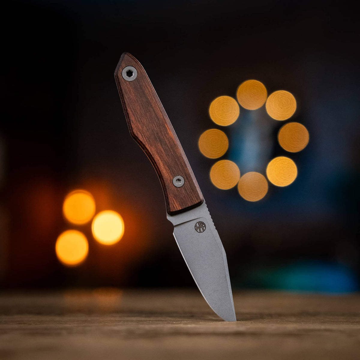 Lookout drop-point knife with DymaLux Walnut handle displayed on a wooden table