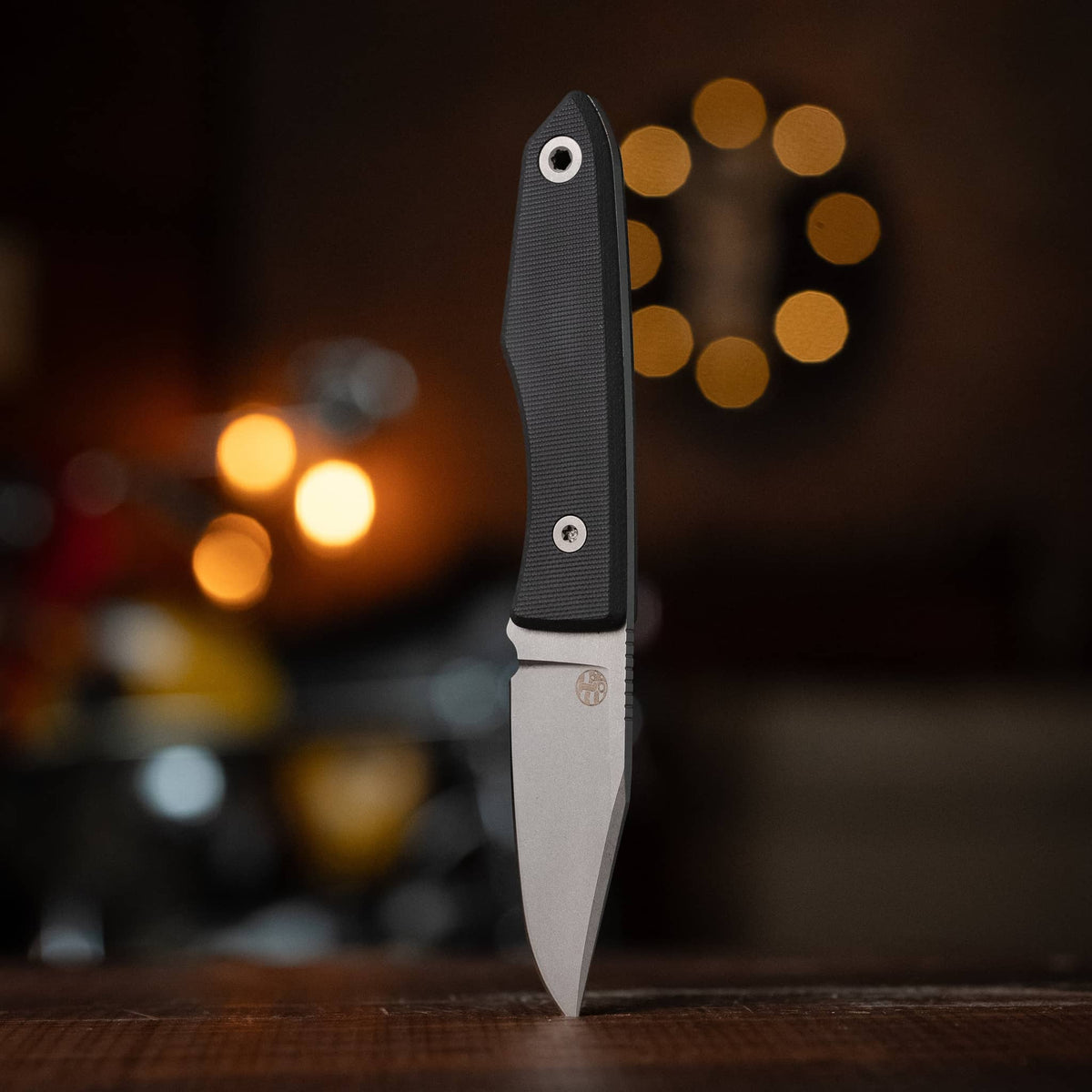 USA Lookout knife with Black G10 handle displayed upright on a wooden table
