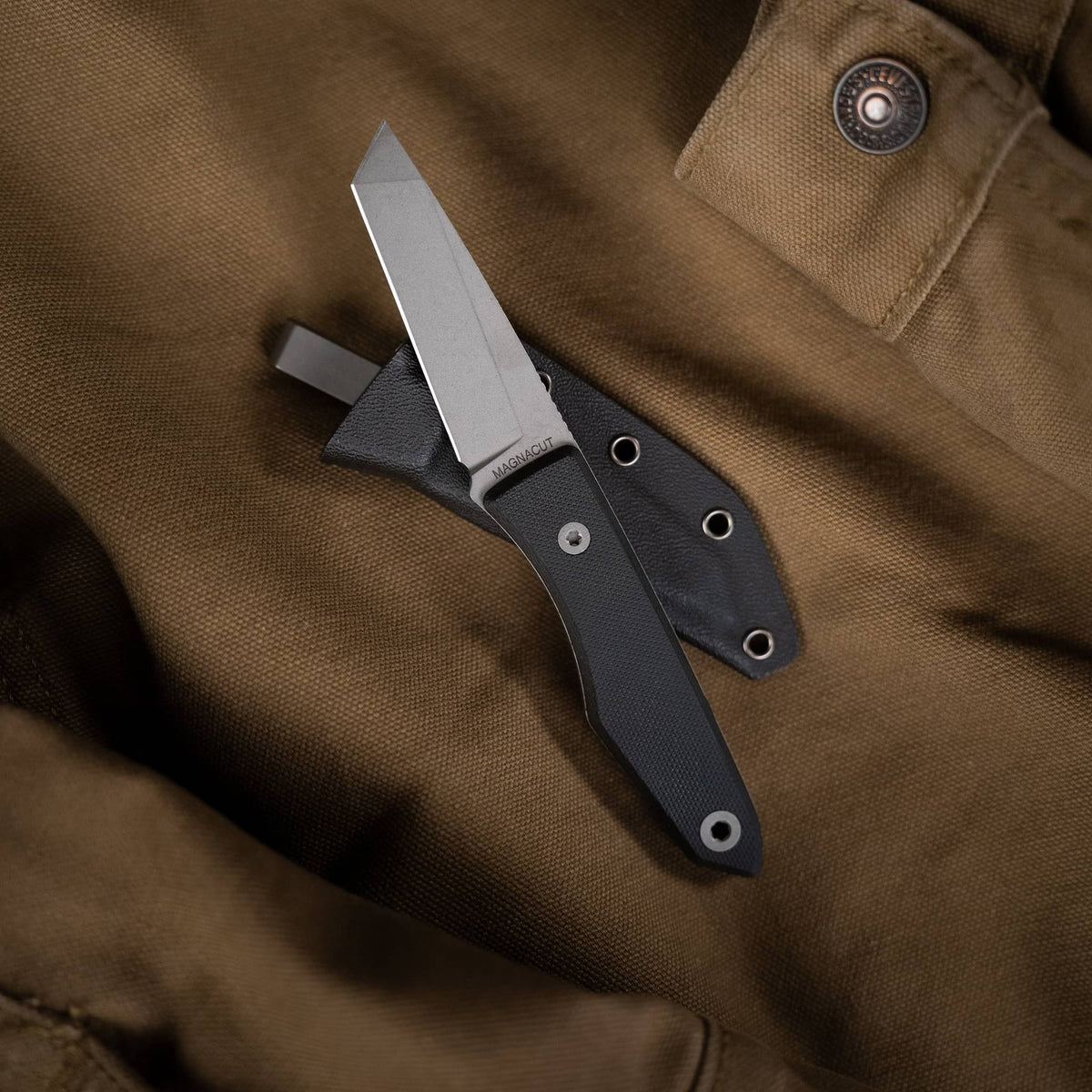 Lookout knife with grooved titanium handle displayed beside two Kydex sheaths
