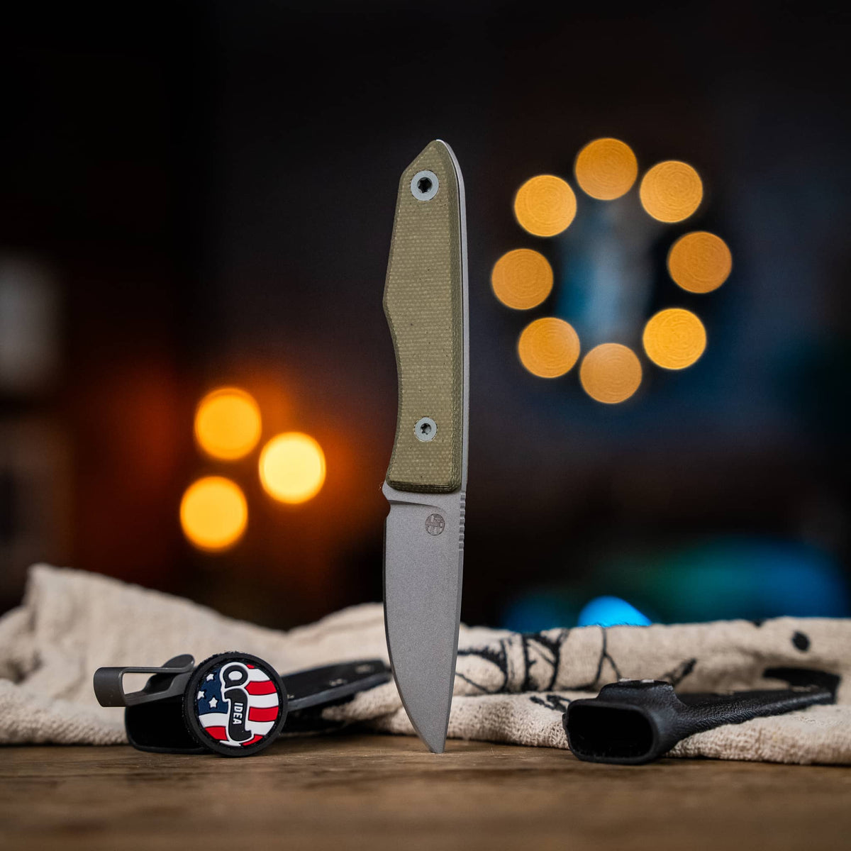 Lookout knife with Green Micarta handle displayed beside two Kydex sheaths
