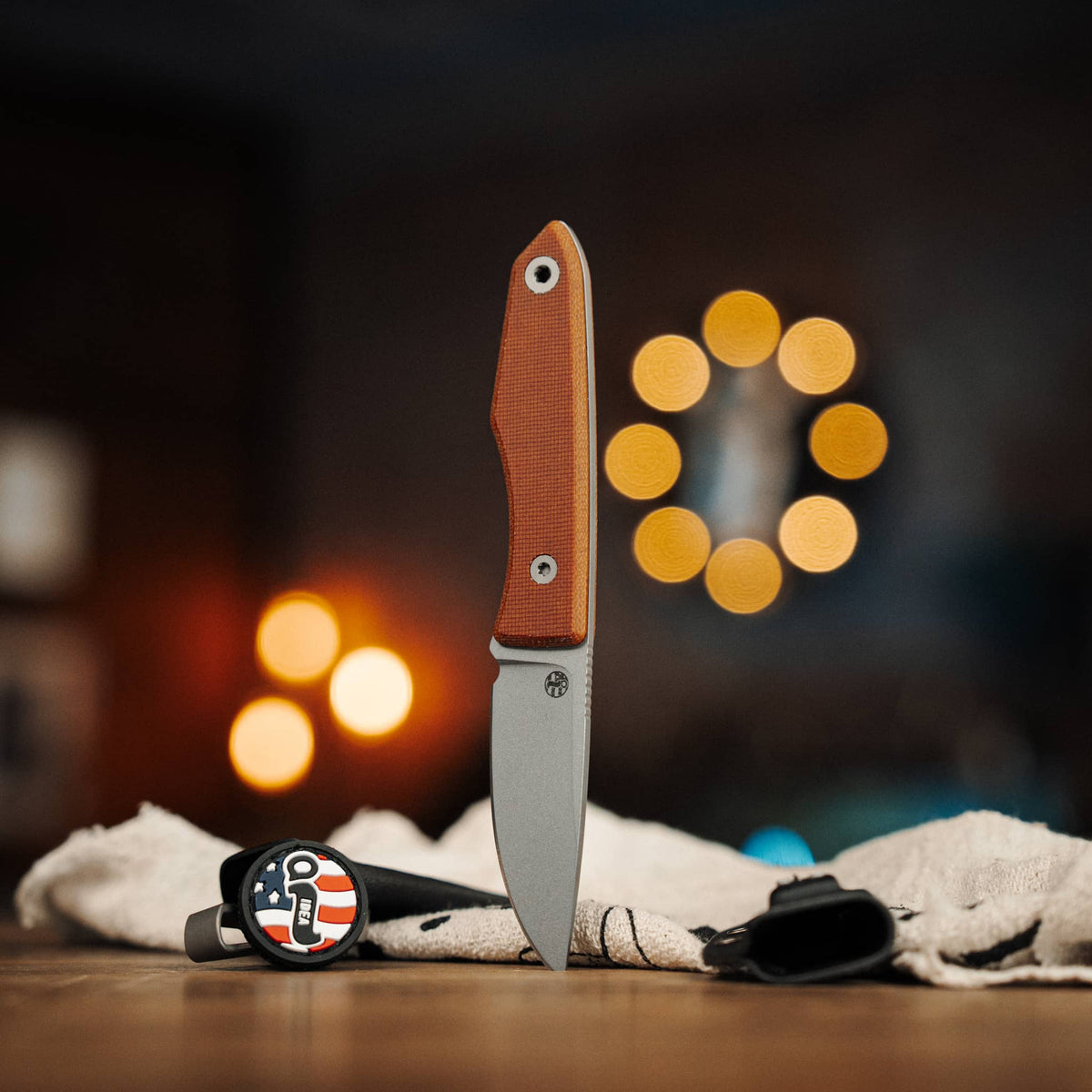 Lookout knife with Natural Micarta handle displayed beside two Kydex sheaths
