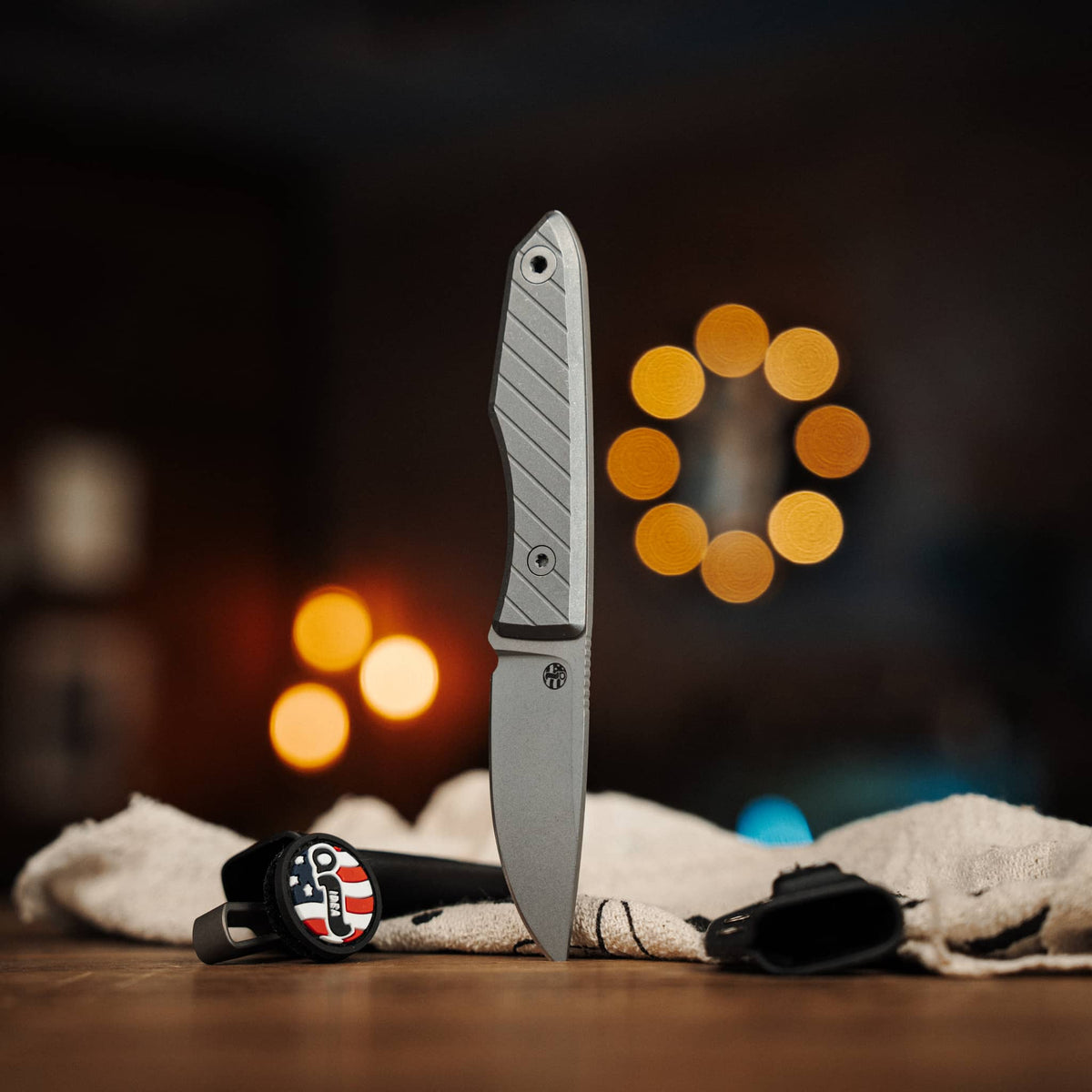 Lookout knife with Black G10 handle displayed beside two Kydex sheaths
