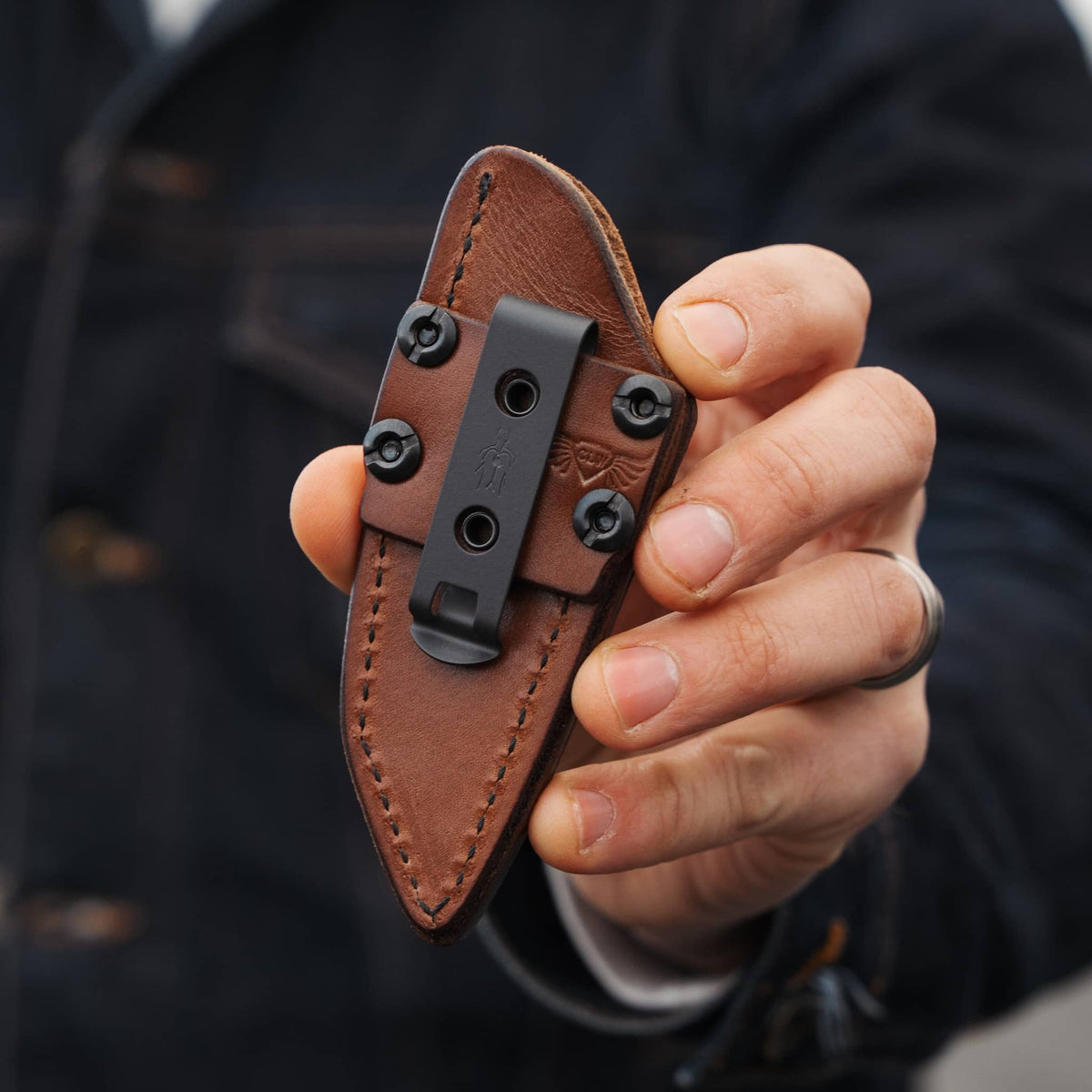 Sheath clip: Back of the Lookout leather sheath held in hand, showing the black pocket clip