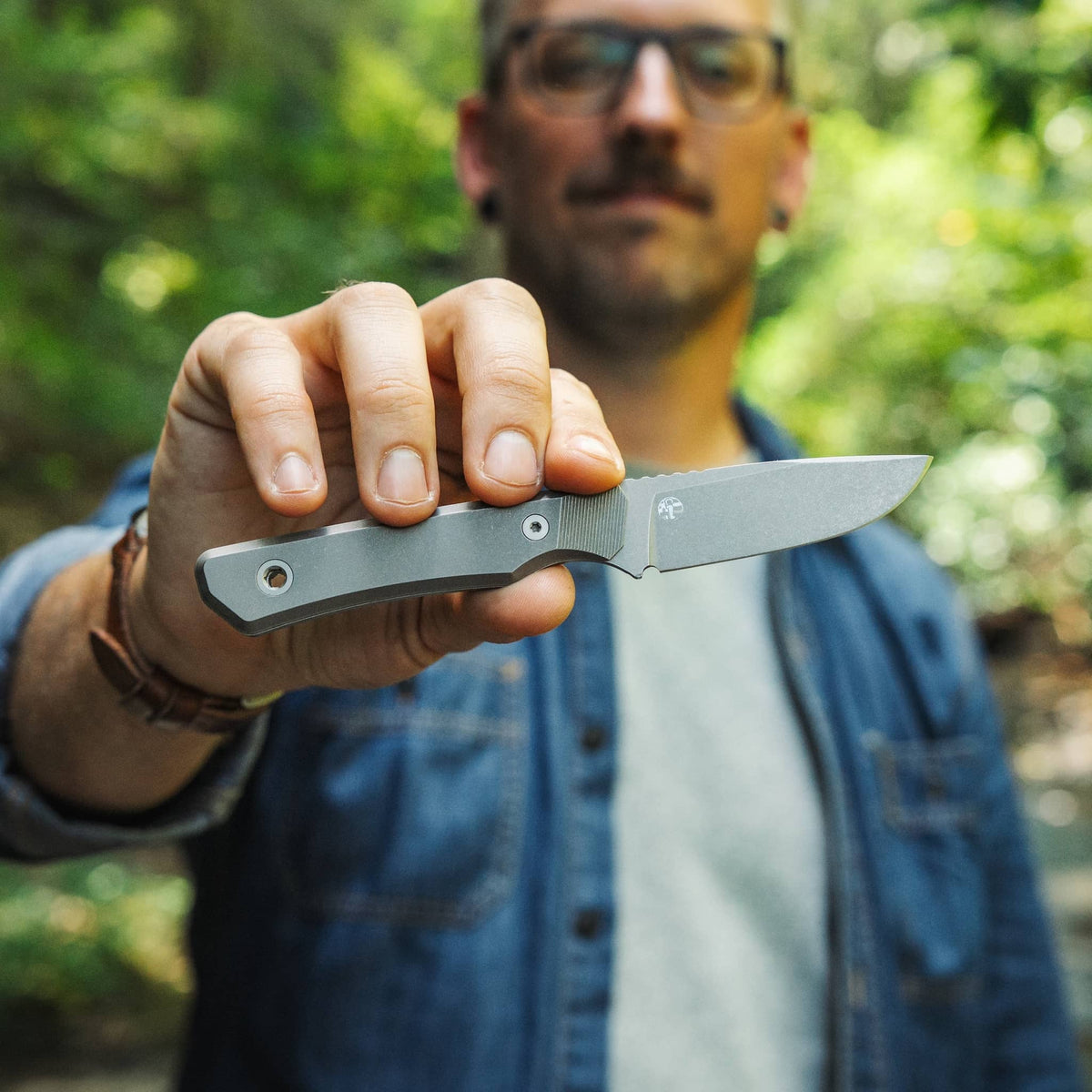 Person holding the titanium-handled Cloudland knife horizontally outdoors