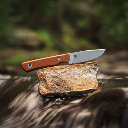 Cloudland knife with Natural Micarta handle displayed on a rock in a flowing stream