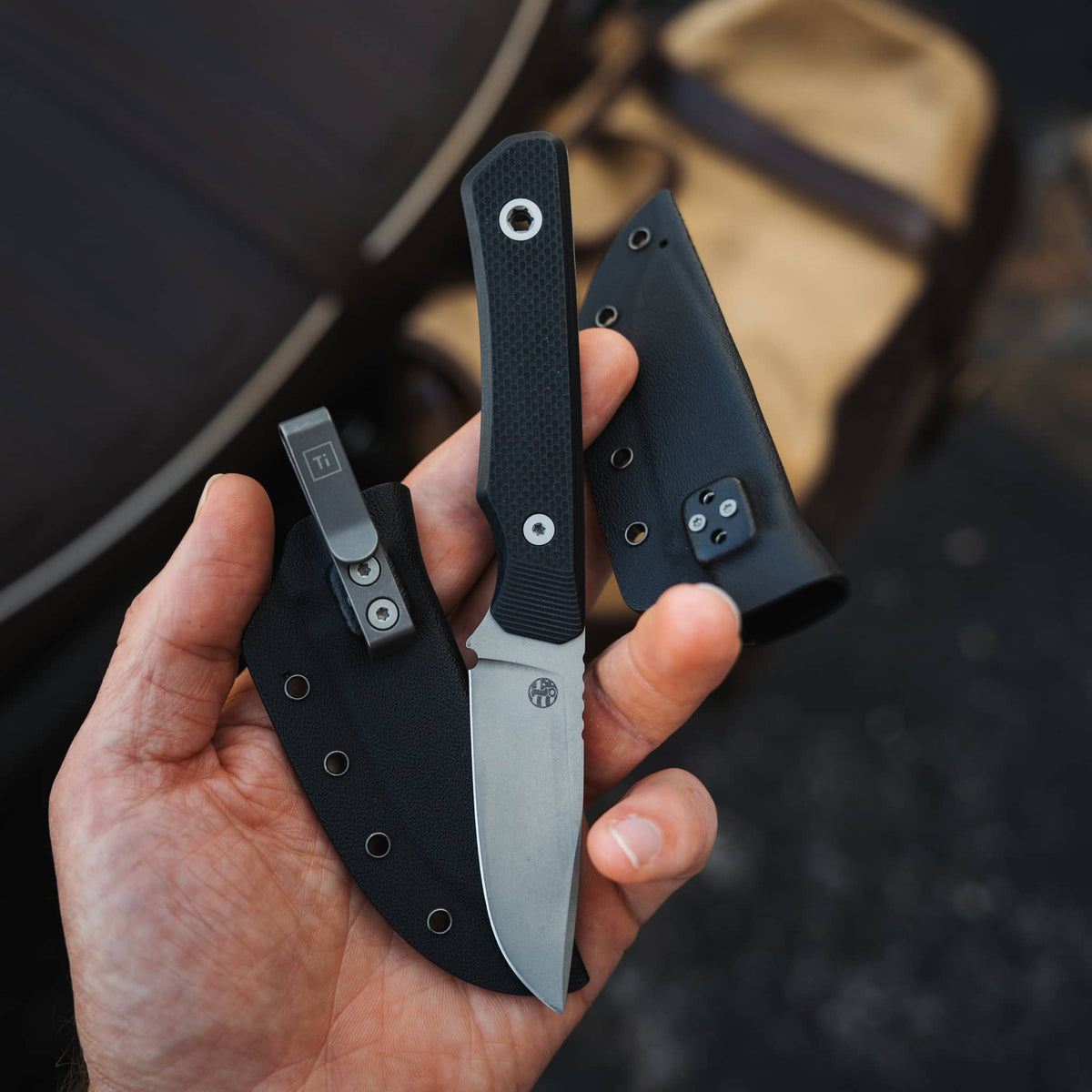 Cloudland knife with Black G10 handle and two Kydex sheaths held in hand, showing the pocket clip