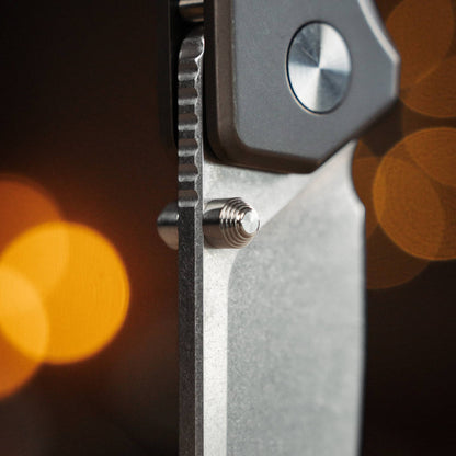 Close-up of the Ti Manu blade, thumb stud, spine jimping, and pivot