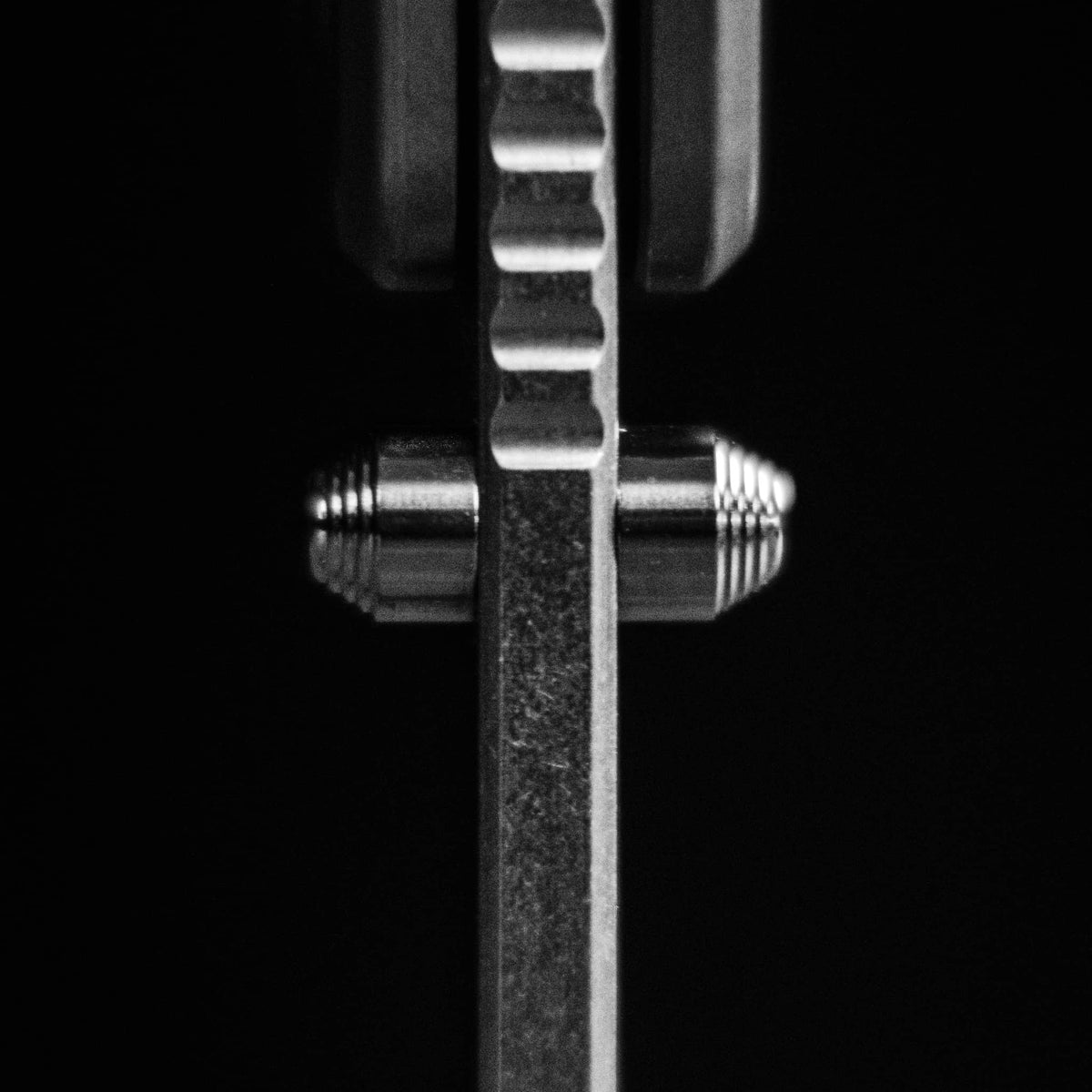 Top view of the Ti Manu blade spine showing dual thumb studs and jimping