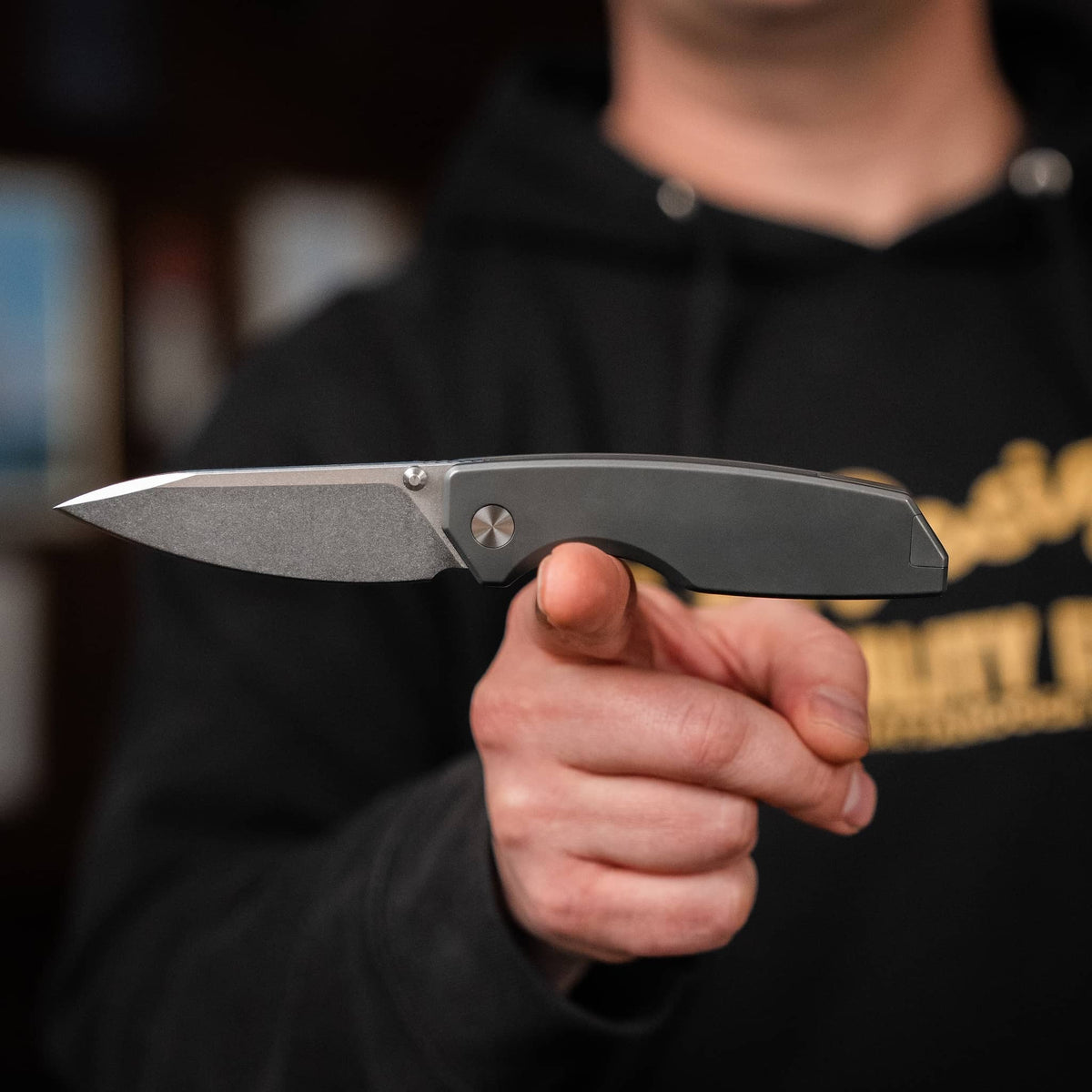 Person holding the open Ti Manu pocket knife horizontally to show its profile